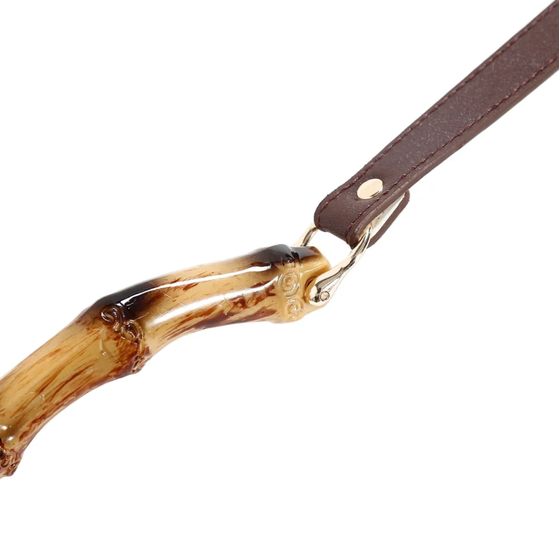 Close-up of PU leather bamboo bondage strap with metal hardware detailing