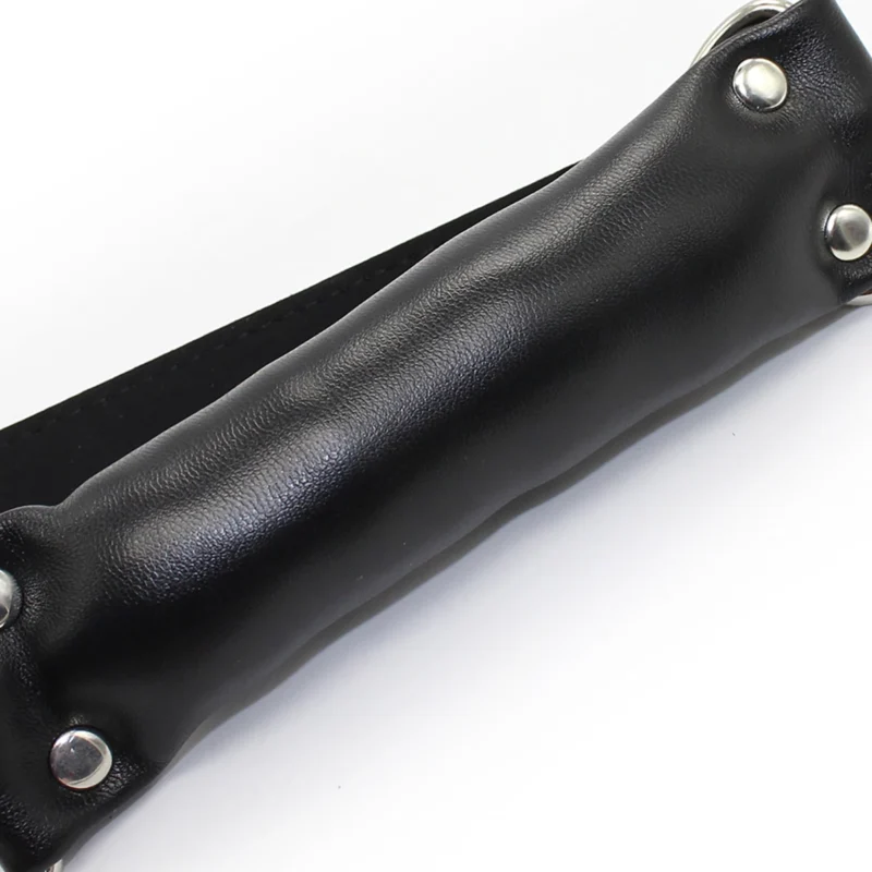 Close-up of cylindrical mouth gag showing PU leather surface and overall shape